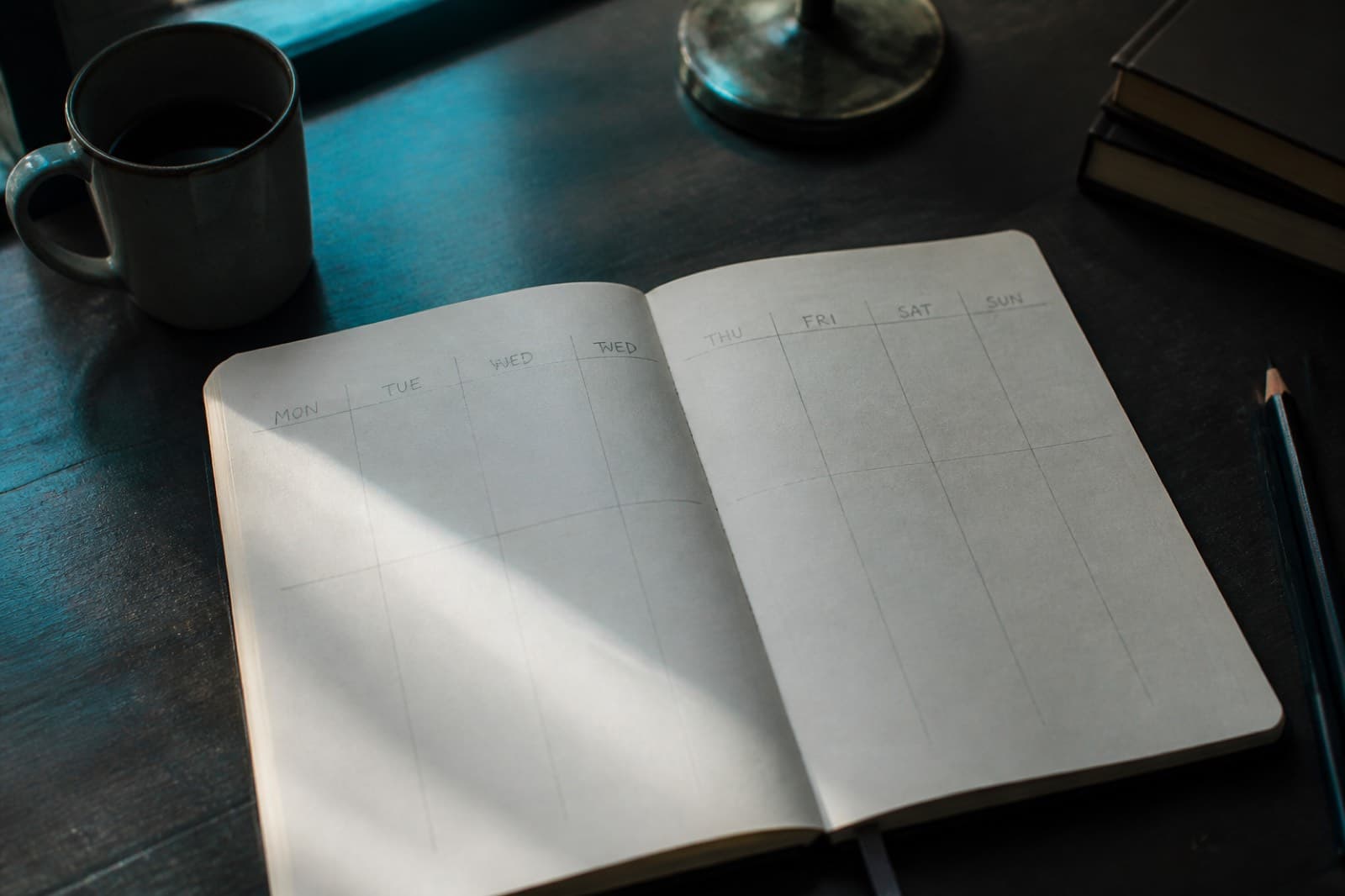A notebook with a seven-day grid sketched in pencil